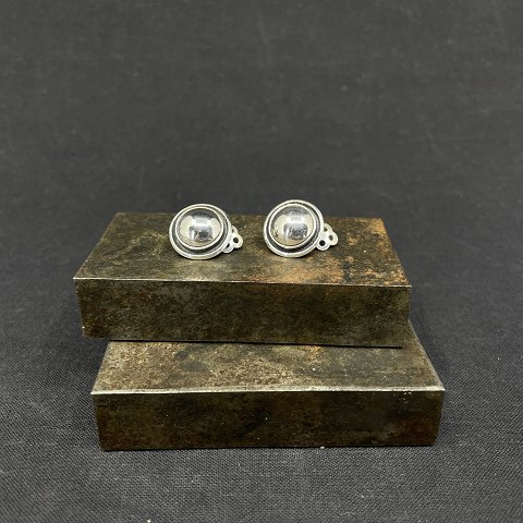 A pair of round ear clips in silver